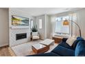 Comfortable living room with fireplace, large television, and lots of natural light at 888 S Valentia St # 14-103, Denver, CO 80247