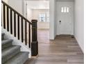 Inviting entryway features luxury vinyl plank flooring, staircase with black railings, and white trim at 25254 E Warren Pl, Aurora, CO 80018