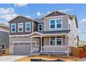 Charming two-story home boasts a covered porch, two-car garage, and attractive mixed-material facade at 25254 E Warren Pl, Aurora, CO 80018