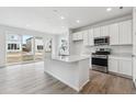 Bright, modern kitchen features stainless appliances, a spacious island, and sliding glass doors at 4464 Boone Cir, Brighton, CO 80601