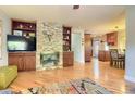 Open-concept living room with hardwood floors, stone fireplace, and built-in shelving at 3835 Pecos St, Denver, CO 80211