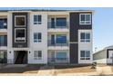 Modern condo building with gray and white exteriors, three stories and black metal balcony railings at 6153 N Ceylon St # 302, Denver, CO 80249