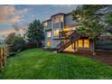 A large grassy backyard featuring a well-maintained lawn, trees, and an elevated wooden deck with stairs at 5048 Rocky Mountain Dr, Castle Rock, CO 80109