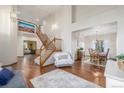 Bright foyer with hardwood floors, a staircase, and views into the living and dining areas at 5048 Rocky Mountain Dr, Castle Rock, CO 80109