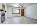 Inviting living room with fireplace, wooden door and a large window offering a view of the outdoors at 6737 Lee St, Arvada, CO 80004