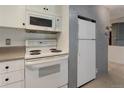 White electric range, microwave, and refrigerator at 2500 S York St # 107, Denver, CO 80210