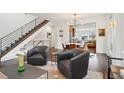 Open concept living and dining area with hardwood floors, modern lighting, and staircase at 1511 S Pennsylvania St, Denver, CO 80210