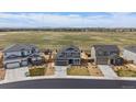 Aerial view of a suburban home with a large field and mountain views in the background at 11741 Magnolia St, Thornton, CO 80233