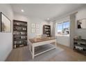 Well-lit home office with large window, built-in bookshelves, and neutral décor at 11741 Magnolia St, Thornton, CO 80233
