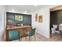 Stylish home office featuring a modern desk, two chairs, and adjacent half bathroom for convenience at 5128 W 26Th Ave # 311, Denver, CO 80212