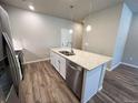Close-up of the kitchen island with stainless steel sink and granite countertop at 8428 Galvani Trl # D, Littleton, CO 80129