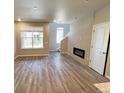 Inviting living room featuring a fireplace, large windows, and wood-look floors at 8428 Galvani Trl # D, Littleton, CO 80129