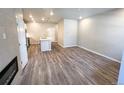 Open-concept living space with fireplace, kitchen island, and wood-look floors at 8428 Galvani Trl # D, Littleton, CO 80129