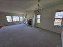 Spacious living room with a fireplace, neutral carpet, and natural light from several windows at 22967 E Mineral Pl, Aurora, CO 80016