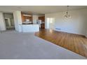 Open-concept living space combining hardwood and carpeted areas, next to the kitchen at 22967 E Mineral Pl, Aurora, CO 80016