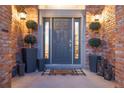 Inviting front entrance with gray door and brick facade at 27319 E Nova Cir, Aurora, CO 80016