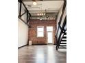 Spacious living room features exposed brick wall, hardwood floors, and industrial staircase at 1111 Osage St # 7, Denver, CO 80204