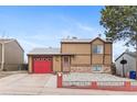 Inviting two-story home showcasing neutral siding, a red garage door, and easy-to-maintain rock landscaping at 3977 S Pitkin Way, Aurora, CO 80013