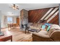 Inviting living room with a stone fireplace, wood paneling, and hardwood floors, perfect for entertaining at 3977 S Pitkin Way, Aurora, CO 80013