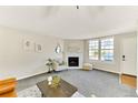 Cozy living room featuring a fireplace, large windows and neutral decor at 5735 W Atlantic Pl # 101, Lakewood, CO 80227