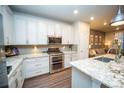 Gourmet kitchen with white cabinets, stainless steel appliances, a stone backsplash, and ample counter space at 359 Courtfield Way, Castle Pines, CO 80108