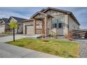 Well-maintained home showcasing the attached two-car garage, lush lawn and an attractive facade at 21436 E Stanford Ave, Aurora, CO 80015