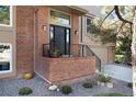 Brick porch and staircase leads to a black front door with sidelights and transom window at 8004 S Oneida Ct, Centennial, CO 80112