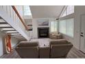 Bright living room featuring a fireplace, cozy seating, and staircase with an angled window at 13781 E Lehigh Ave # E, Aurora, CO 80014