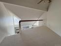 Open loft area with neutral carpeting and a railing overlooking the living space below at 13781 E Lehigh Ave # E, Aurora, CO 80014