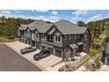 Stunning view of the townhouse exterior with gray siding, private garages, and landscaped surroundings at 31191 Black Eagle Dr # 304, Evergreen, CO 80439