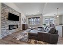 Modern living room features a stone fireplace, hardwood floors, and a comfortable sectional at 31191 Black Eagle Dr # 304, Evergreen, CO 80439