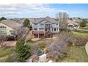 Expansive backyard with multi-level deck, patio, and lush greenery surrounding this beautiful home at 22090 E Arbor Dr, Aurora, CO 80016