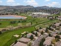 Stunning aerial view showcases the neighborhood, golf course, and lakes with mountain views at 16631 Red Cliff Cir, Morrison, CO 80465
