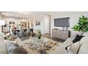 Open living room showcasing stylish furniture and a large TV at 9876 Ceylon Ct, Commerce City, CO 80022