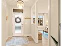 Bright entryway featuring a frosted glass door, stylish lighting, and an adjacent view of the living space at 9734 Bennett Peak St, Littleton, CO 80125