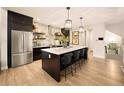 Modern kitchen with dark cabinets, stainless steel appliances, a large island, and pendant lighting at 9734 Bennett Peak St, Littleton, CO 80125