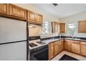 Functional kitchen featuring wooden cabinets, black countertops, and modern appliances at 2831 W Irvington Pl, Denver, CO 80219