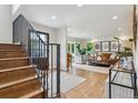 Bright entryway featuring hardwood floors, a staircase with iron railings, and a view into the living room at 5766 S Fulton Way, Greenwood Village, CO 80111