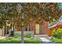Charming home with brick exterior, mature trees, green lawn, and well-maintained landscaping at 814 S High St, Denver, CO 80209