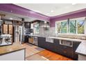 Bright kitchen with stainless steel appliances, mosaic backsplash, farmhouse sink and wood floors at 801 Hanover St, Aurora, CO 80010