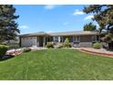 Charming single-story home with a lush green lawn and beautiful front yard landscaping at 2301 Dunbar Ct, Longmont, CO 80501