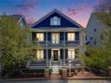 Two-story home showcasing a double porch and manicured front yard at dusk at 8156 E 35Th Ave, Denver, CO 80238
