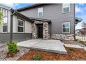 Inviting front entrance with stone accents and well-manicured landscaping at 9756 Mount Kataka Pt, Littleton, CO 80125