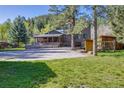 Well-maintained home with a spacious driveway, covered porch, stone accents, and lush greenery surrounding the property at 11531 S Deer Creek Rd, Littleton, CO 80127