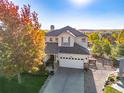 An aerial view of this two-story home shows a spacious driveway, lush landscaping, and a neighborhood setting at 7630 Chickaree Pl, Littleton, CO 80125