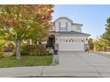 Charming two-story home featuring a large front yard, mature tree, and a two-car garage with updated paint and landscaping at 7630 Chickaree Pl, Littleton, CO 80125