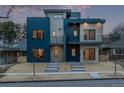 Modern home showcasing a blue and gray exterior, complemented by a minimalist landscaped yard at 535 Josephine St, Denver, CO 80206
