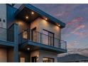 Upward angled view of a modern two-story home, with a private balcony, and exterior lights at 535 Josephine St, Denver, CO 80206