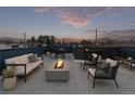 Relaxing rooftop deck featuring a fire pit, comfortable seating, and views of the surrounding neighborhood at 535 Josephine St, Denver, CO 80206