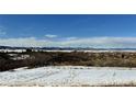 Mountain view of snowy landscape with some dry brush under a blue sky at 5774 Sioux Dr, Sedalia, CO 80135